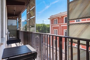 A balcony with a table and chairs, overlooking a street with buildings. - Dimora Italia in the Centre Bari (Bari)