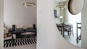 A modern living room with a sofa, coffee table, and dining area with chairs and a table. - Dimora Italia in the Centre Bari (Bari)
