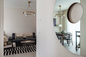 A modern living room with a sofa, coffee table, and dining area with chairs and a table. - Dimora Italia in the Centre Bari (Bari)