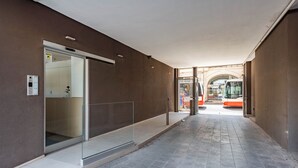 A hallway with a glass door entrance, a tiled floor, and a bus in the background. - Dimora Italia in the Centre Bari (Bari)