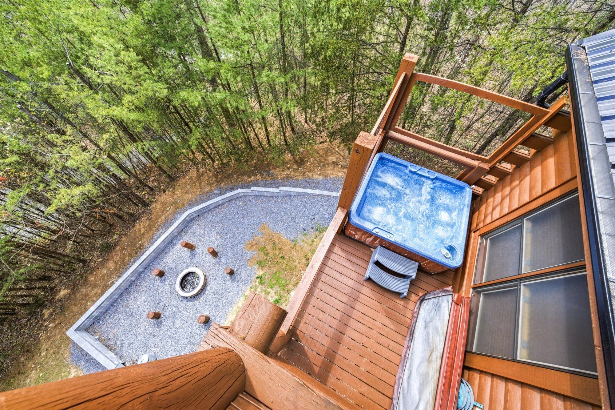 Una vasca idromassaggio su un pontile di legno con vista su una foresta.