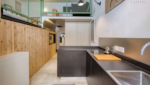 Eine moderne Küche mit schwarzem Arbeitsplatz, Spüle aus Edelstahl und Schneidebrett aus Holz.