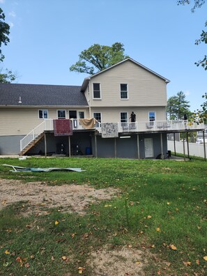 A two-story house with a covered porch and a fenced deck. - The Hideout, a spacious 5BR, 3BT home that's perfect for families friends. (Lanham)