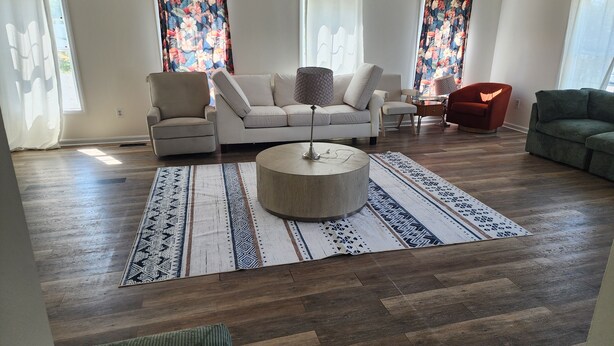 A spacious living room with a sofa set, a round coffee table, and a patterned rug. - The Hideout, a spacious 5BR, 3BT home that's perfect for families friends. (Lanham)