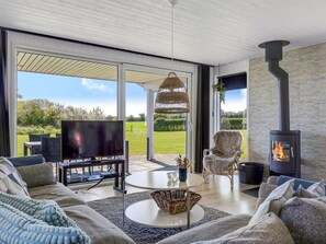 Ein modernes Wohnzimmer mit Fernseher, Sofa und Kamin.