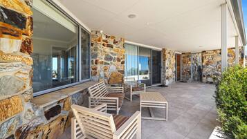 A covered outdoor seating area with stone walls and modern furniture.