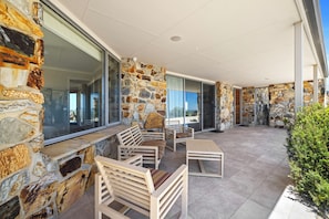 A covered outdoor seating area with stone walls and modern furniture.