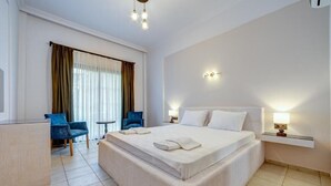 A hotel room with a large bed, a desk, a chair, and a window with curtains. - Lagoonia Sun Boutique Hotel (Ölüdeniz)