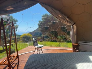 A tent with a hexagonal pattern, a bed, a chair, and a wooden ladder. - Immerse yourself completely in nature; relax in the tub, surrounded by the whirlpool and the stars. (Pianillo)