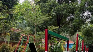 Um parquinho com escorrega, estruturas de escalada e balanços.
