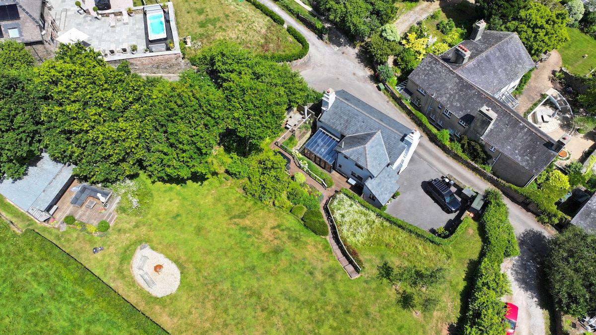 Vista aérea de una zona residencial con casas, piscina y césped bien cuidado.