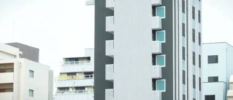 A multi-story building with a modern design, featuring balconies and a flat facade.