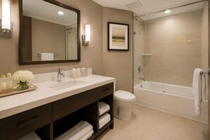 A bathroom with a large mirror, a sink, a toilet, and a shower area. - Mayfairs Hotel (Toronto)