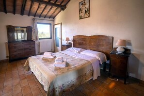 A bedroom with a wooden bed, a dresser, a nightstand, and a window with curtains. - Siena Holiday Home With Pool for 4 (Siena)