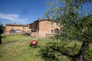 A stone building with a courtyard, a large tree, and a flower arrangement. - Siena Holiday Home With Pool for 4 (Siena)