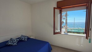 Una camera da letto con un letto, una finestra vista e una lampada a soffitto.