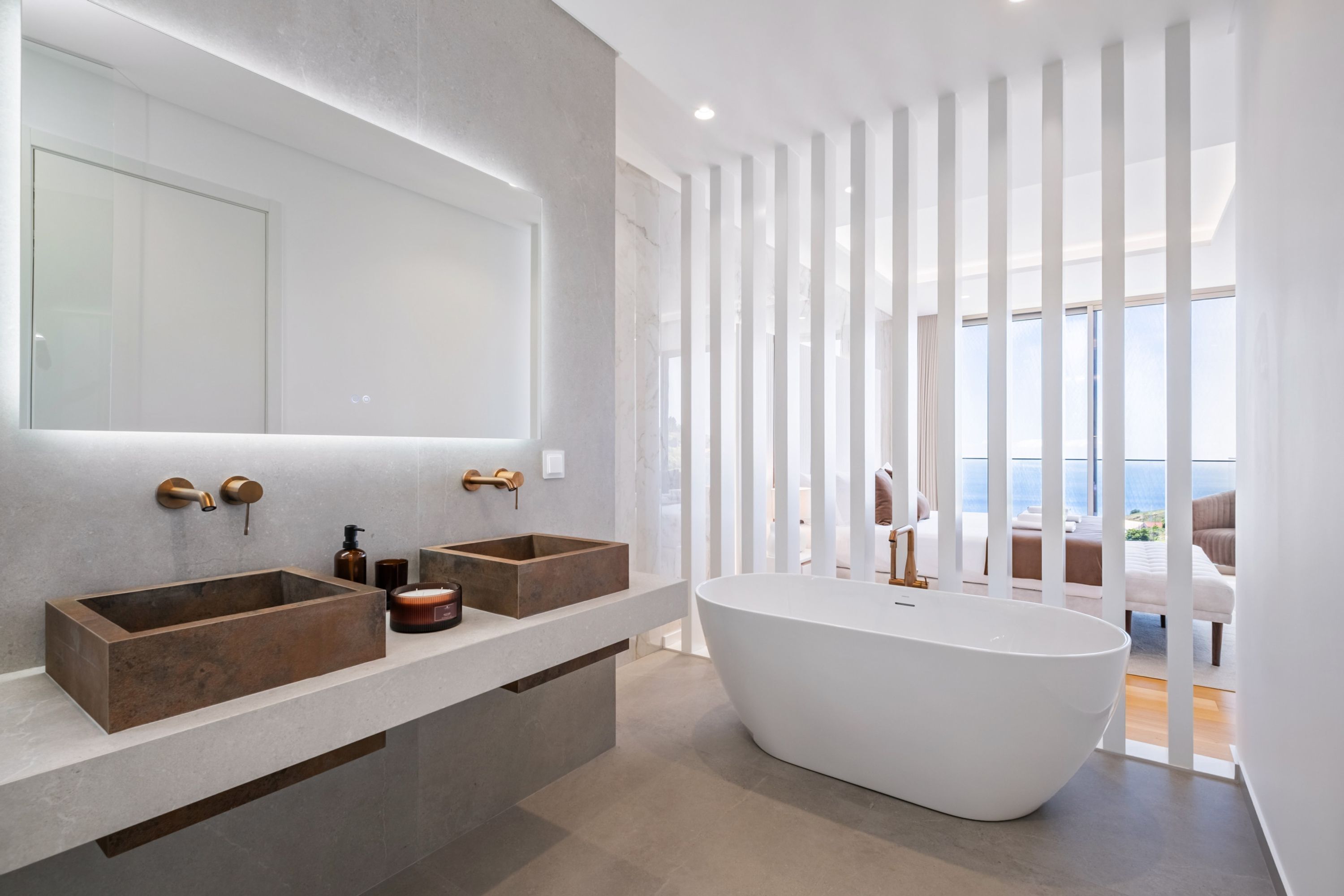 Une salle de bain moderne avec une baignoire sur pieds, deux lavabos et un grand miroir.