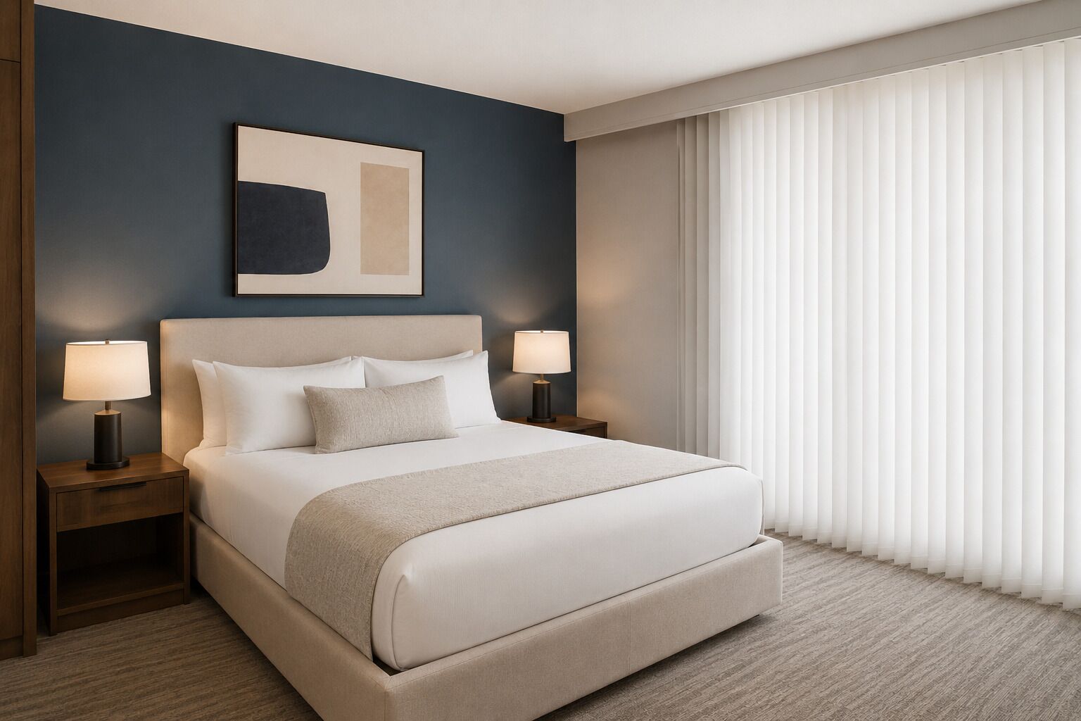 Ein Hotelzimmer mit einem großen Bett, zwei Nachttischen inklusive Lampen, einer Kopfteil, einem Fenster mit Jalousien und einem abstrakten Kunstwerk an der Wand.
