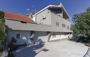 Ein zweistöckiges Haus mit rotem Ziegeldach, einer Satellitenschüssel und einer Garage.