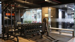 A gym with exercise equipment, a rack of dumbbells, and a bench. - CityHouse TERA Emerald (Ho Chi Minh City)
