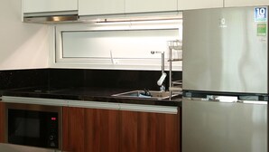 A kitchen with a stainless steel refrigerator, a microwave, and a sink. - CityHouse TERA Emerald (Ho Chi Minh City)