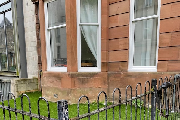 A building with large windows, a brick facade, and a metal fence. - Property (Glasgow)