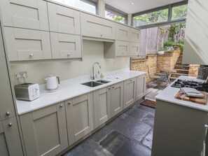 Een moderne keuken met een inbouwspoelbak, een broodrooster en een fornuis.