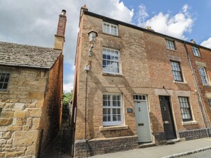 Un bâtiment en pierre de deux étages, avec une façade en briques, portant le numéro 34, et une porte blanche.