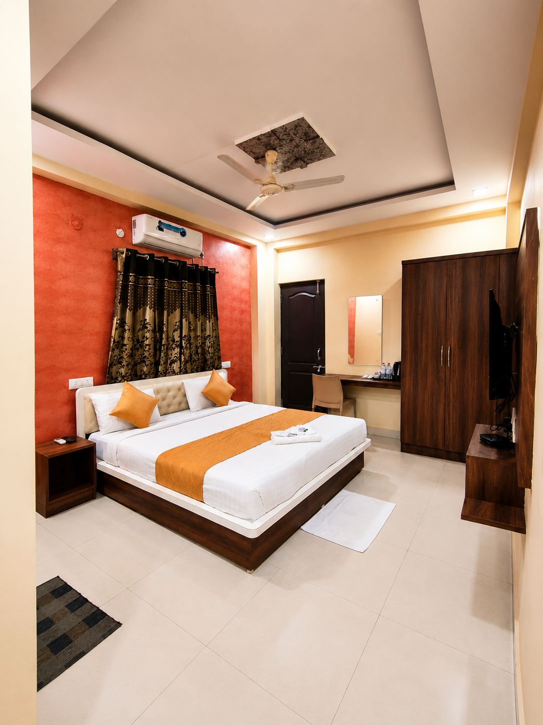 Une chambre d’hôtel comprenant un lit, une armoire, un bureau et un téléviseur.