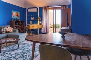 A living room with a sofa, a coffee table, a dining table with chairs, a bookshelf, and a painting on the wall. - Posillipo Luxury House (Napoli)