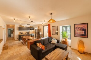 Un salon moderne avec un canapé, une table basse et un coin repas.