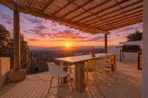A patio with a table and chairs, a grill, and a view of the sunset. - Heated Plunge Pool | Mountain View’s (Málaga)