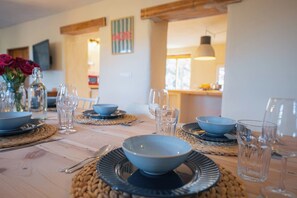 A dining table set with blue bowls, plates, and glasses, with a woven placemat underneath. - Heated Pool | Villa with Mountain View (Málaga)