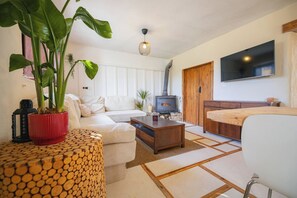 Ein Wohnzimmer mit einer Couch, einem Couchtisch, einem Fernseher und einem Kamin.