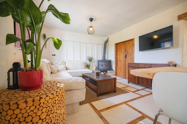 Ein Wohnzimmer mit einer Couch, einem Couchtisch, einem Fernseher und einem Kamin.