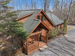 A log cabin with a porch, a chimney, and a satellite dish. - The Toasted Turkey (Gatlinburg)