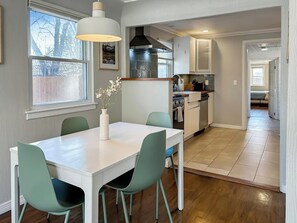 A modern kitchen with a dining area, wooden flooring, and a view of the outdoors. - 4BR|Garage Parking|Dog Friendly|Olde Town Arvada (Arvada)