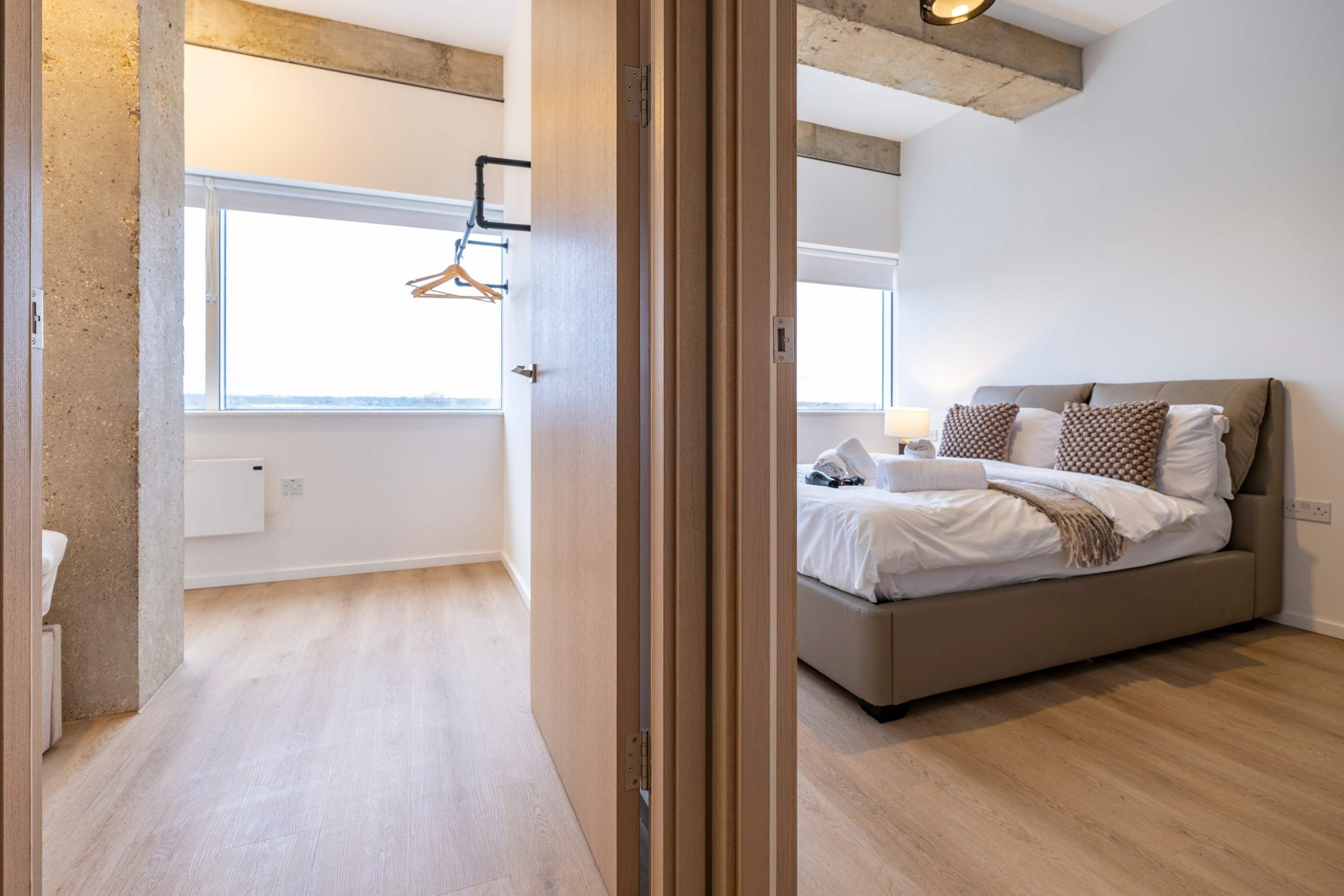 A bedroom with a bed, bedside table, and a window.
