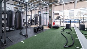 A gym with exercise equipment, a punching bag, and a treadmill.