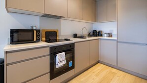 A modern kitchen with a microwave, oven, and coffee maker.