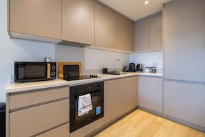 A modern kitchen with a microwave, oven, and coffee maker.