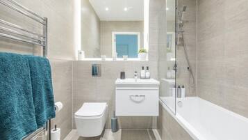 Un baño moderno con inodoro, lavabo y bañera.