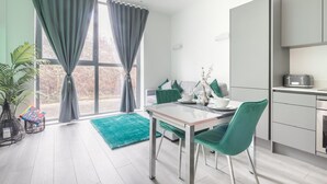 A modern kitchen with a dining area, large windows, and a view of the outdoors. - Entire Rental Unit in Linford Wood (Milton Keynes)