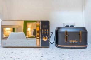 Une cuisine moderne avec un four à micro-ondes et un grille-pain posés sur un plan de travail.