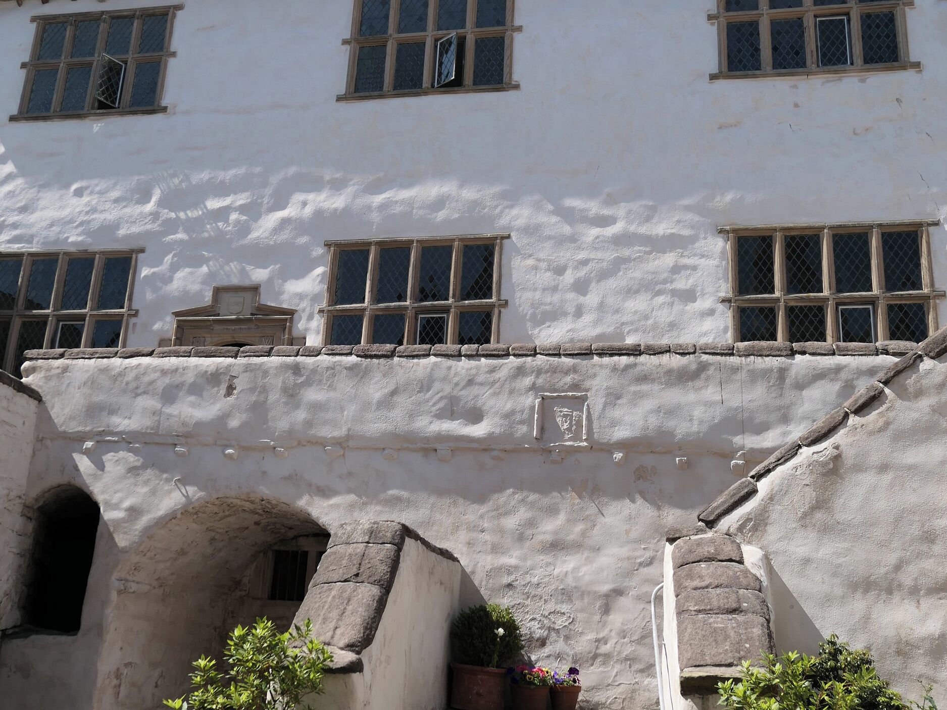 A building with multiple windows, a stone archway, and a small door.
