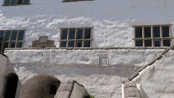 A building with multiple windows, a stone archway, and a small door.