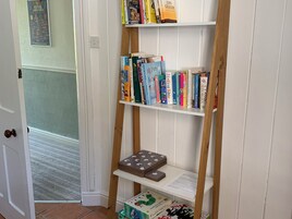 Una estantería con varios libros y un juego de mesa.