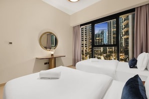 A hotel room with two beds, a round mirror, a small table, and a large window with a city view. - FIRST CLASS | 2BR | near Burj Khalifa & Dubai Mall (Downtown)