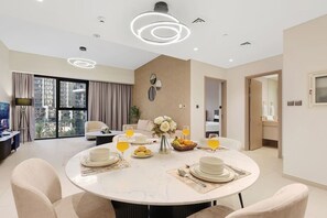 A modern dining area with a round table, chairs, and a city view. - FIRST CLASS | 2BR | near Burj Khalifa & Dubai Mall (Downtown)