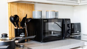 A kitchen with a black Sharp microwave, a coffee maker, and a toaster. - West Hampstead Hub - 1 bedroom spacious apartment (Greater London)